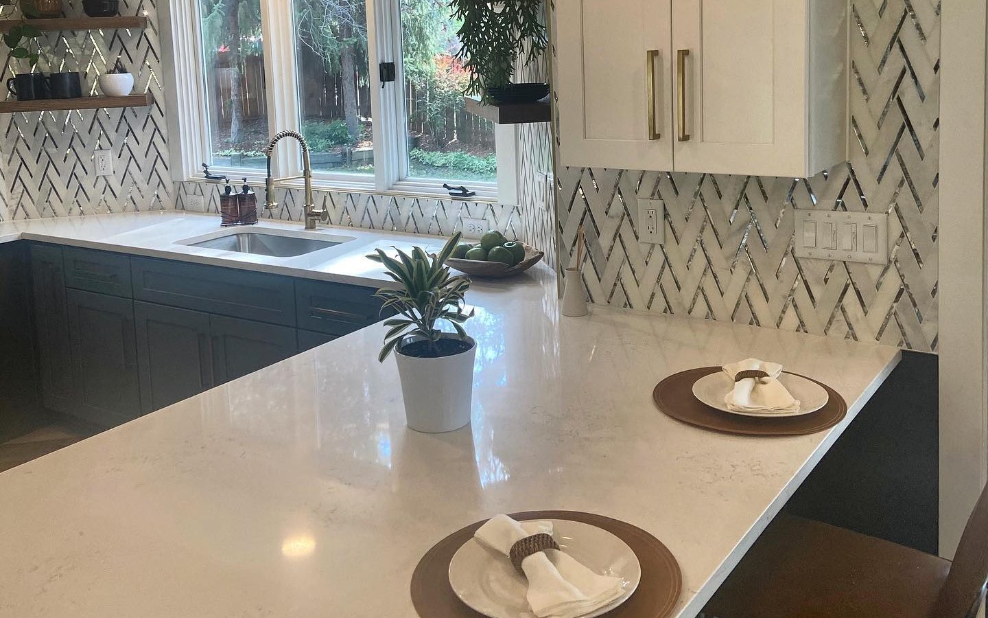 White herringbone kitchen backsplash under a black range hood