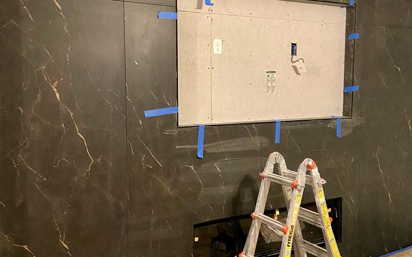 Large-format wall tile being set with leveling clips and tape