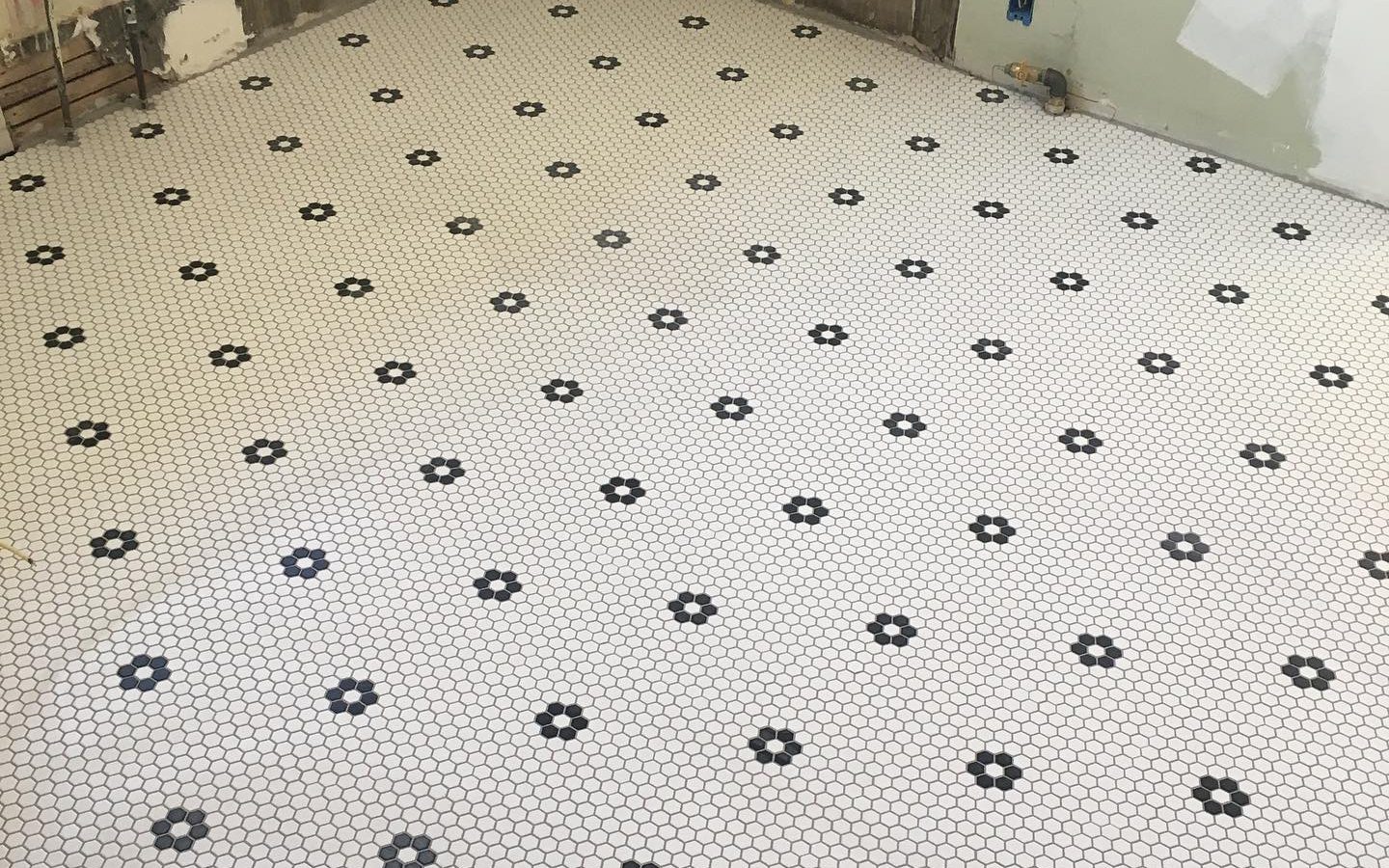 Black and white hex mosaic floor being laid