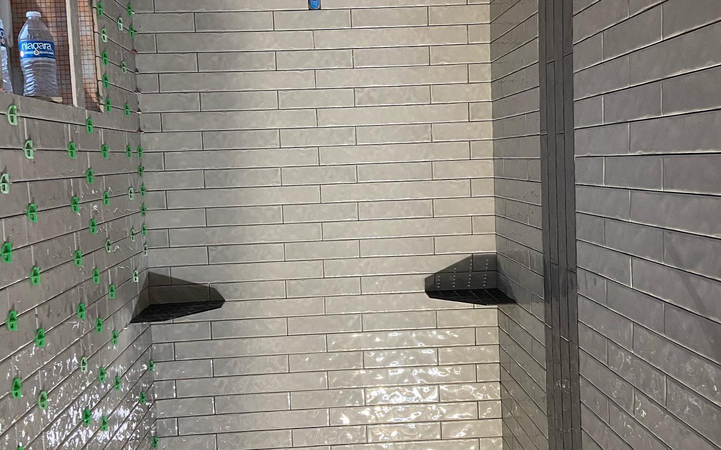 Wall tile held flat with leveling clips while the thinset cures